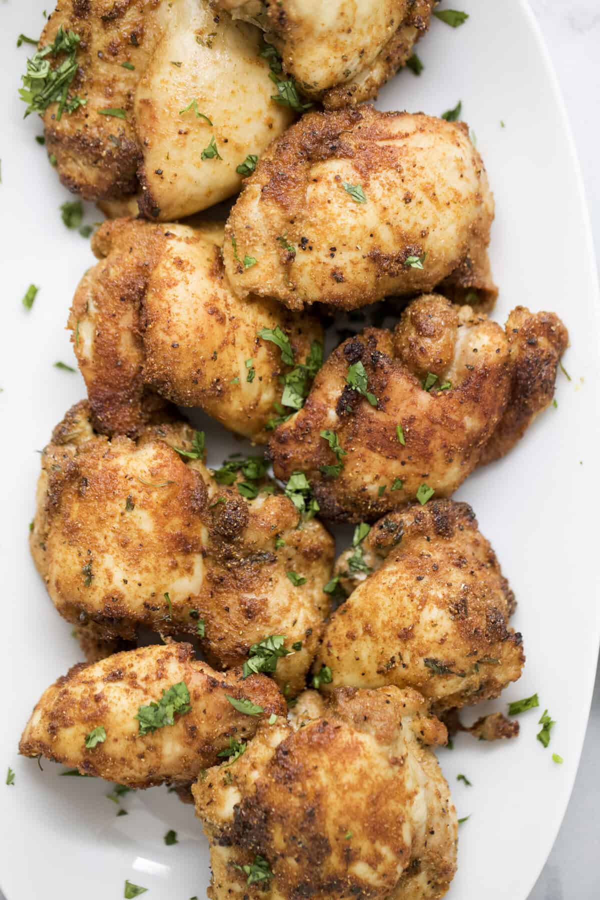 Crispy air fryer chicken thighs on platter.