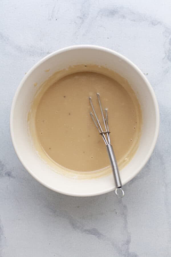 Whisk in bowl with maple tahini sauce.
