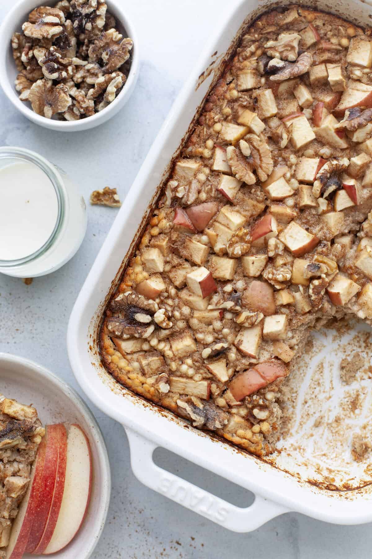 Cinnamon baked apple oatmeal in baking dish with portion removed.