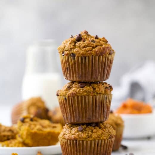 3 chocolate chip pumpkin protein muffins stacked on countertop.