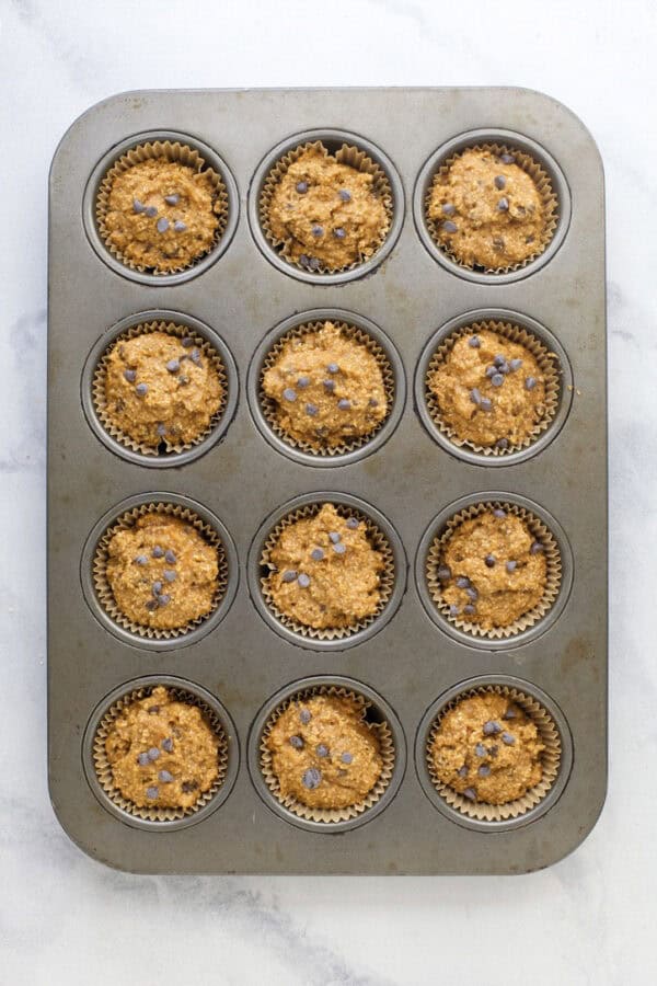 Unbaked pumpkin protein muffins in pan.